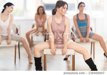 Fit girl performing high heels choreography with chair at group class 136408947
