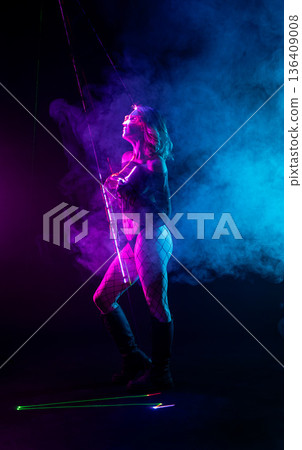 Cyberpunk woman in neon laser light show with smoke and fog 136409008