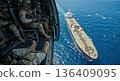 Military soldiers in helicopter watching cargo ship in ocean. Aerial view of special forces operation and maritime security 136409095