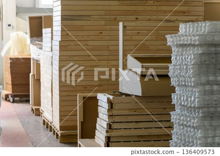 Manufacturing workshop scene with stacked wooden bed frames 136409573