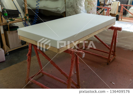 Foam mattress core on wooden frame in upholstery workshop 136409576