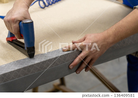 A person uses a pneumatic stapler A person uses a pneumatic stapler 136409581