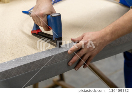 A person uses a pneumatic stapler 136409582