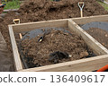 Sifting organic soil and compost for sustainable reforesting and garden preparation, using hand tools outdoors 136409617