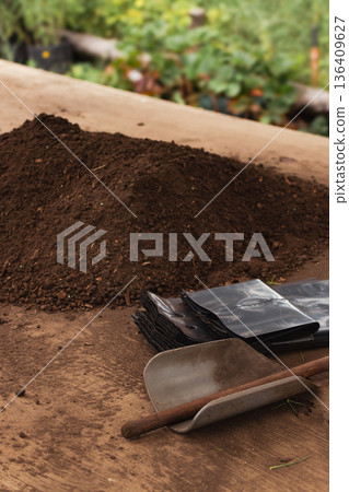 Close up of soil and organic compost mix on a wooden surface, ready for filling seedling bags Close up of soil and organic compost mix on a wooden surface, ready for filling seedling bags 136409627