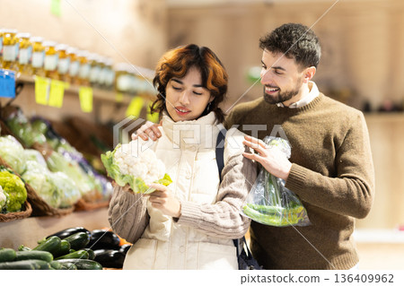 Married couple choose ripe cauliflower together at grocery supermarket Married couple choose ripe cauliflower together at grocery supermarket 136409962
