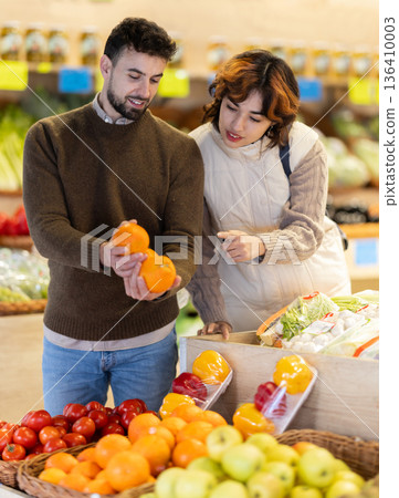 Young couple choose oranges in store Young couple choose oranges in store 136410003