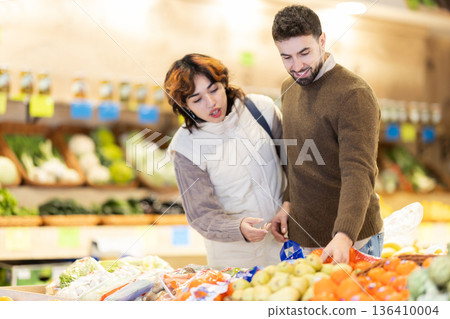 Couple shopping in vegetable store and buy elect pear Couple shopping in vegetable store and buy elect pear 136410004