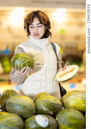 Girl shopping in vegetable store and buy elect melon 136410018