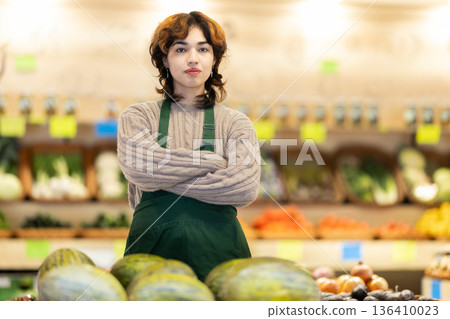 Portrait of young female grocery store employee in fruit and vegetable department 136410023