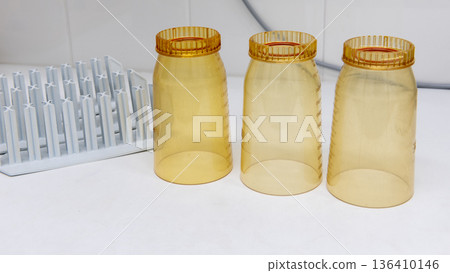 Plastic laboratory funnels for water filtration, amber glass bottle and tubes racks on workbench Plastic laboratory funnels for water filtration, amber glass bottle and tubes racks on workbench 136410146