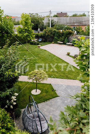 Top view of landscaped backyard with lawn, patio pavers, benches and cozy garden seating Top view of landscaped backyard with lawn, patio pavers, benches and cozy garden seating 136410309