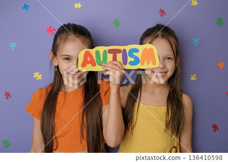 Two smiling children holding colorful autism sign with puzzle pieces. Autism awareness, social equality, neurodiversity support, inclusive education and childhood acceptance concept. Two smiling children holding colorful autism sign with puzzle pieces. Autism awareness, social equality, neurodiversity support, inclusive education and childhood acceptance concept. 136410598