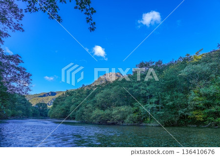 Panoramic view of the Azusa River and the fresh green forests of Kamikochi, Shinshu, with Mount Yakedake towering in the background 136410676