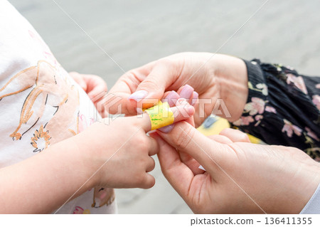 Child finger injury. Toddler receiving adhesive support outdoors. Family wellbeing concept. Child finger injury. Toddler receiving adhesive support outdoors. Family wellbeing concept. 136411355