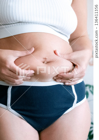 Overweight woman. Female body touching belly. Body positivity co 136411356
