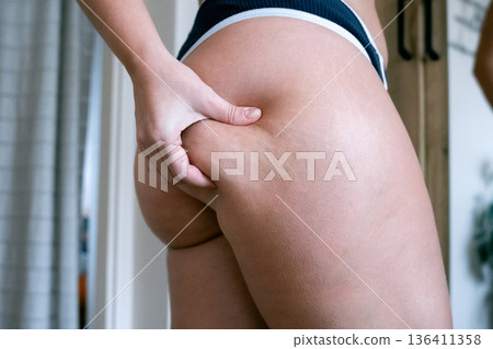 Woman weight check. Female examining torso fat indoors. Self car Woman weight check. Female examining torso fat indoors. Self car 136411358