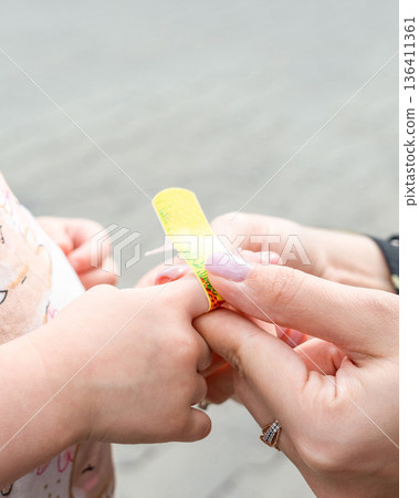 Child wound care. Toddler finger protected with adhesive strip. Parenting safety concept. Child wound care. Toddler finger protected with adhesive strip. Parenting safety concept. 136411361