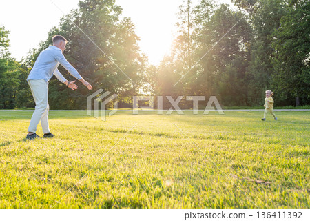 Parenting outdoors. Happy father and toddler girl in park. Parenting outdoors. Happy father and toddler girl in park. 136411392