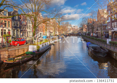 Sunny Canal with Boats and Traditional Houses in Amsterdam, Netherlands Sunny Canal with Boats and Traditional Houses in Amsterdam, Netherlands 136411731