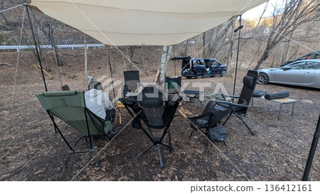 Forest campsite: Chairs lined up under a tarp and a bonfire area 136412161