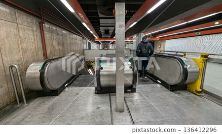 Passengers heading to the platform on an escalator at an Italian subway station Passengers heading to the platform on an escalator at an Italian subway station 136412296