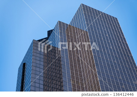Office building in business district. Skyscraper building architecture. Business skyscraper of glass. Modern glass building. Skyscraper in city. City downtown with skyscraper. Low angle Office building in business district. Skyscraper building architecture. Business skyscraper of glass. Modern glass building. Skyscraper in city. City downtown with skyscraper. Low angle 136412446