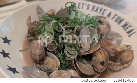 清酒蒸貝類菜餚的特寫鏡頭，並以蔥花點綴。 136412496