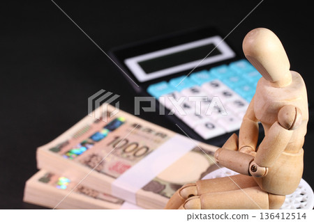 Business image of a stack of bills, a calculator, and a wooden doll Business image of a stack of bills, a calculator, and a wooden doll 136412514