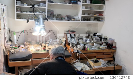鐘錶工坊裡的工匠正在辦公桌前修理手錶。 136412748