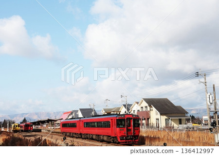 一列JR豐橋本線列車正行駛在宮地站附近，宮地站是通往阿蘇神社的門戶。 136412997