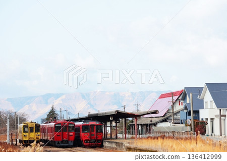 A JR Toyohashi Main Line train stops at Miyaji Station with the Aso Mountains in the background. A JR Toyohashi Main Line train stops at Miyaji Station with the Aso Mountains in the background. 136412999