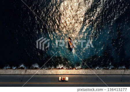 Aerial View of Vehicle on Coastal Road Alongside Ocean Surface with Reflections Aerial View of Vehicle on Coastal Road Alongside Ocean Surface with Reflections 136413277