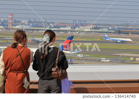 Passengers watching planes take off from the observation deck 136414740
