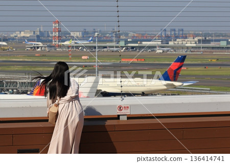 Woman looking out at the runway at Haneda Airport's observation deck Woman looking out at the runway at Haneda Airport's observation deck 136414741