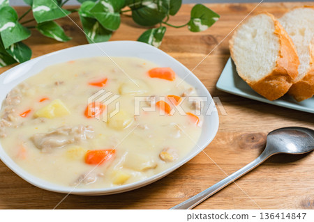 Cream stew served on a white plate. A warm image of a home-cooked meal with bread. Cream stew served on a white plate. A warm image of a home-cooked meal with bread. 136414847