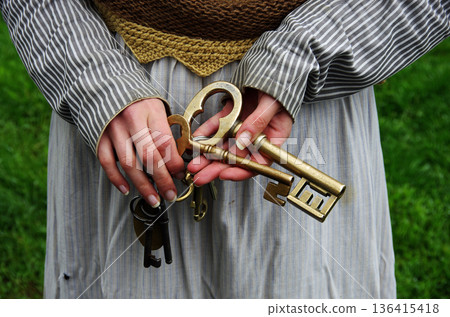 Woman in Icelandic traditional costume holding an old key 136415418