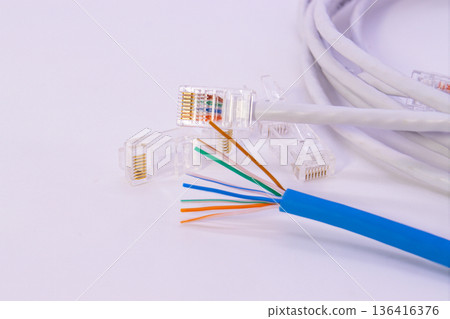 Blue Cat6 and white Cat5 LAN cables with eight inner wires exposed, network cable structure showing internal copper lines Blue Cat6 and white Cat5 LAN cables with eight inner wires exposed, network cable structure showing internal copper lines 136416376