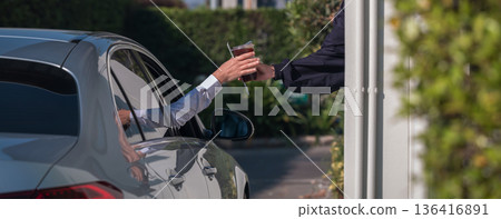 Hand Man in car receiving coffee in drive thru fast food restaurant 136416891