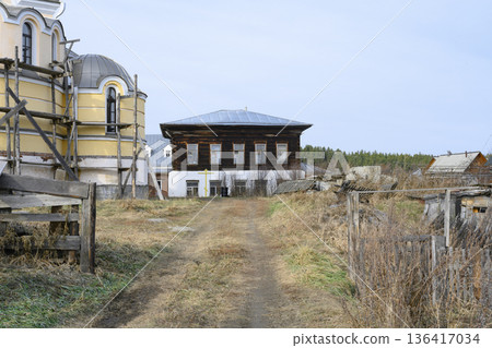 A residential wooden monastery building next to a church under construction in Siberia, Russia A residential wooden monastery building next to a church under construction in Siberia, Russia 136417034