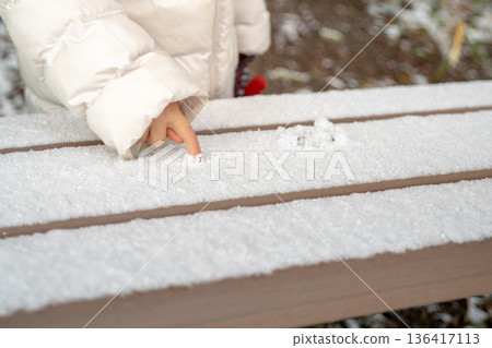 A child touching the piled snow A child touching the piled snow 136417113