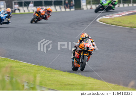 摩托車賽車手領先，後面的賽車緊追不捨，場面十分激烈。 136418325