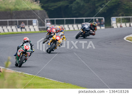 一群摩托車賽車手並排高速過彎——公路賽中的激烈時刻 136418326