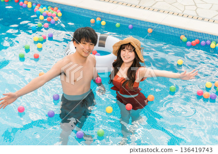 一對年輕的亞洲夫婦在度假勝地的泳池玩耍 136419743