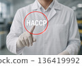 Food safety engineer pressing HACCP button on virtual interface to activate hazard control and verification systems inside clean processing environment 136419992