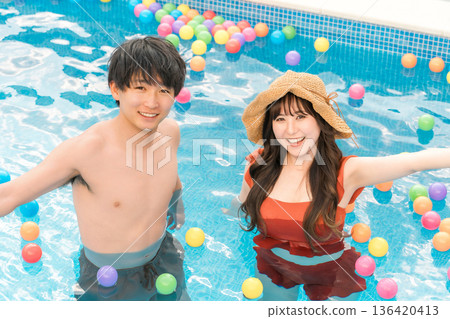 Young Asian couple playing in the pool on a resort vacation Young Asian couple playing in the pool on a resort vacation 136420413