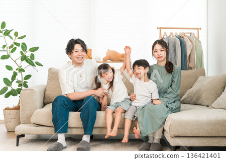 Family sitting on the sofa in the living room, parent and child, family, family of four Family sitting on the sofa in the living room, parent and child, family, family of four 136421401