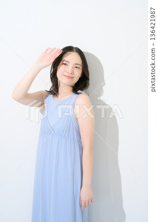 一位女子在白色背景下沐浴陽光 一位女子在白色背景下沐浴陽光 136421987