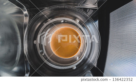 Coffee cup heating inside microwave oven modern kitchen lifestyle concept Coffee cup heating inside microwave oven modern kitchen lifestyle concept 136422352