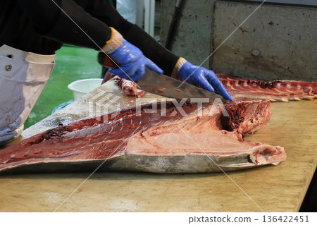 Raw bluefin tuna being butchered by a tuna craftsman Raw bluefin tuna being butchered by a tuna craftsman 136422451